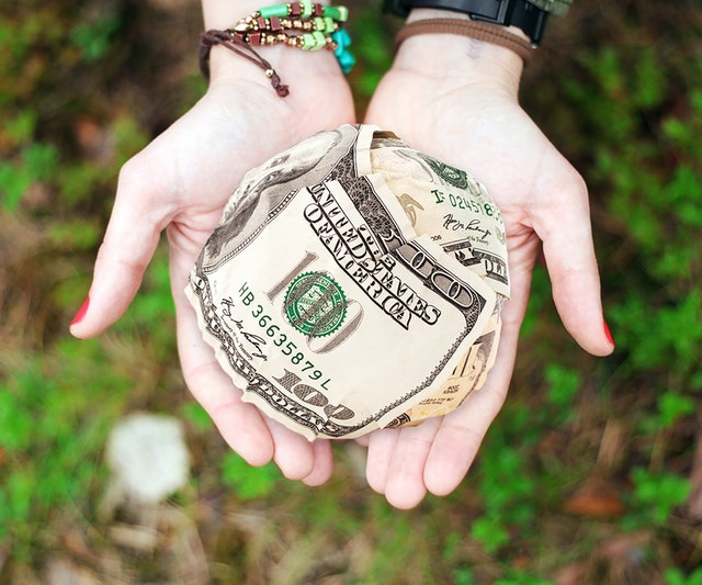 Girl holding ball of money in palm